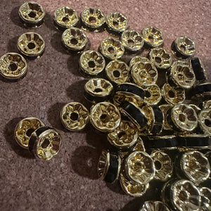 50 black and gold rondelle spacers.