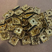 Load image into Gallery viewer, 25 black and gold rondelle spacers.