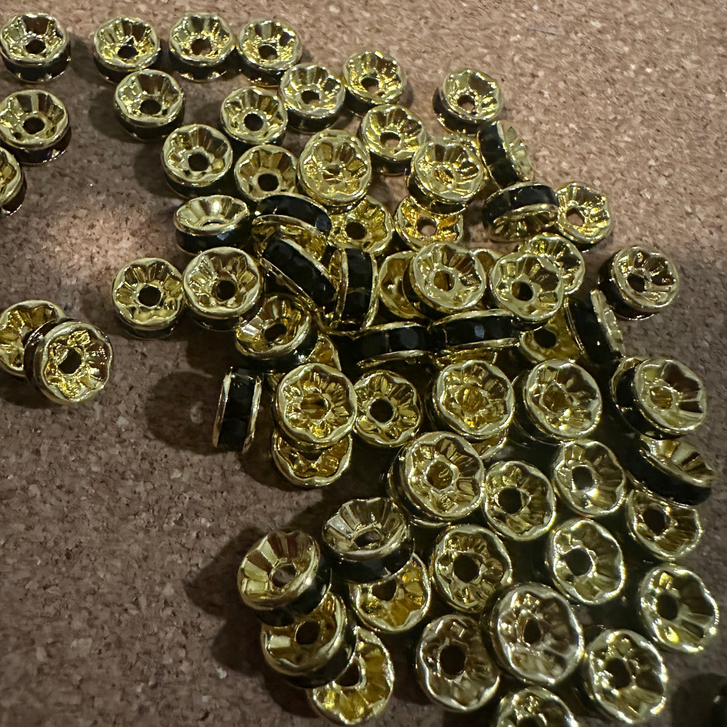 50 black and gold rondelle spacers.