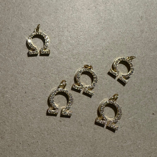 2 Gold pave Omega charms.