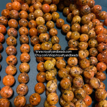 Load image into Gallery viewer, Orange and black beads.